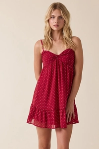 Detail of red polka dot summer dress showing neckline knot and ruffle hem texture