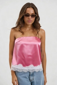 Detail showing bright pink satin tube top with delicate white eyelash lace hem and texture