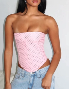 Detail of pink polka dot corset top with tie-waist and asymmetrical hem design