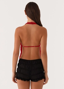 Vue arrière du haut licou rouge avec bretelles fines et short noir à volants