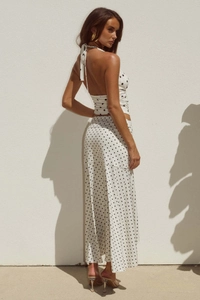 Detail von weißem Polka-Dot-Halter-Oberteil und langem Rockset mit elegantem Stoff