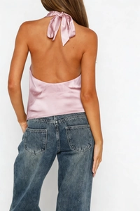 Detail view of pink satin halter top featuring a backless design and neck ribbon tie