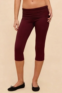 Detail view of burgundy high-waisted capri leggings with smooth rolled-edge waistband