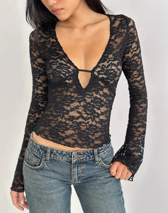 Detail of sheer floral lace texture and deep V-neckline on a slim fit long sleeve black top