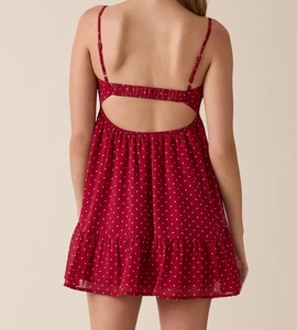 Detail of red polka dot dress featuring open back design and adjustable spaghetti straps