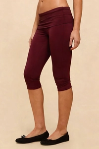 Detail of high-waist wine red cropped yoga leggings with folded waistband and slim fit
