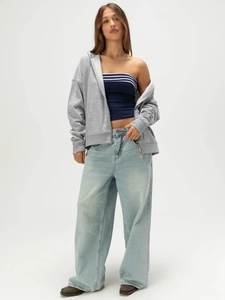 Women's casual light gray zip-up hoodie paired with a striped tube top and wide jeans