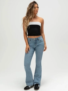 Women's backless tube top with black and white polka dots paired with flared jeans