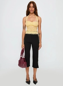 Close-up of yellow lace halter top with ruched bust detail and slim fit design