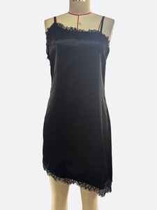 Close-up of black satin dress featuring delicate lace trim and asymmetric hemline