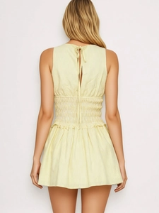 Detail view of yellow striped sleeveless dress featuring smocking and back tie-up ribbon