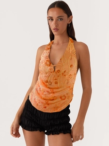 Haut licou orange à paillettes et short noir à volants pour un look de fête chic
