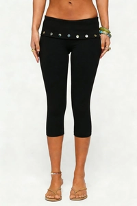 Detail of high waisted black capri leggings featuring decorative buttons at the waistline