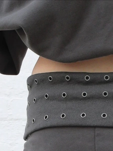 Detail der dunkelgrauen Taille mit dreireihigen Silberösen und elastischem Bund