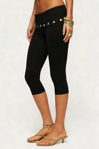 Close-up of high-waist black capri leggings featuring decorative buttons on the waistline
