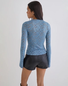 Detail shot of sheer floral lace texture on the light blue long-sleeve top