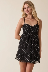 Detailed view of polka dot dress with spaghetti straps and ruffled hem design