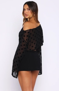 Vue latérale du haut noir à pois en mesh avec manches transparentes évasées