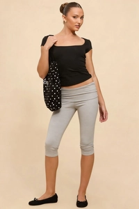 Close-up of black square-neck slim-fit t-shirt and grey cropped leggings with polka dot tote