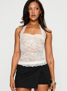 Close-up of white floral lace texture and eyelash lace trim on a halter neck top