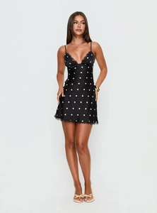 Détails d'une robe en satin noir à pois avec bordure en dentelle et décolleté en V