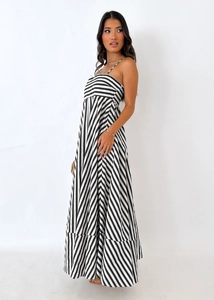 Detail of a black and white striped maxi dress with thin straps and a flowy tiered skirt