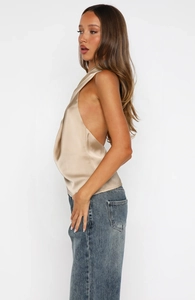 Detailed side view of backless satin halter top with elegant drape and metallic finish