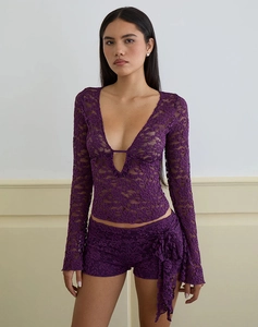 Detailed view of purple floral lace texture on long sleeve V-neck top with ribbon bow