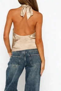 Detail view of champagne satin halter top showing open back with a ribbon bow tie