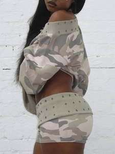 Detail von Camouflage-Oberteil und Shorts mit metallischen Ösen auf dem Stoff