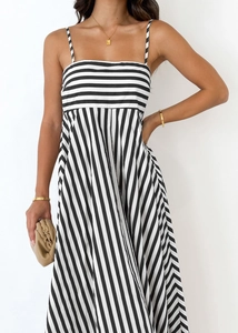 Detailed view of women's striped maxi dress with contrast patterns and pleats