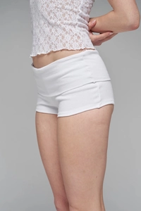 Detailed view of white ribbed high-waisted shorts with lace top on a female model