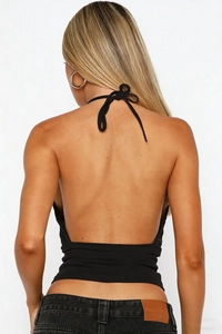 Détail du haut dos nu noir à licou avec nœud au cou et design dos ouvert élégant