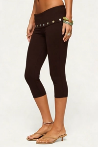 Detail of high waist fold-over waistband with decorative buttons on brown capri leggings