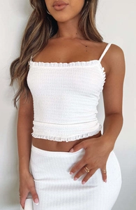 Detail van witte gesmockte crop top met fijne ruches en elastische getextureerde stof