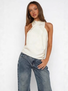 Elegant ivory satin halter top with cross-neck design paired with classic blue denim jeans
