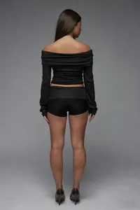 Rear view of slim fit high-waisted black shorts and long-sleeved crop top set for women