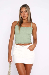 Detail van de saliegroene gesmokte camisole stof met ruches aan de zoom en textuur