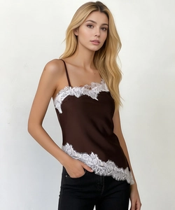 Detail of satin camisole featuring white floral lace trim and asymmetrical hemline