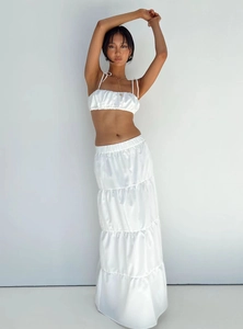Detailed texture of white satin crop top and layered tiered maxi skirt two-piece set