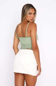 Detailweergave van de saliegroene bandeau top met ruches en gesmokte textuur