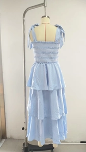 Detail of light blue tiered dress featuring smocked bodice and shoulder tie knots