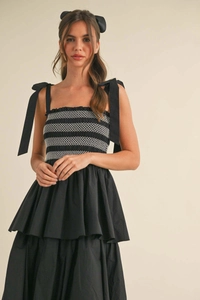 Detail of smocked bodice with white diamond embroidery and tie shoulder straps on black dress
