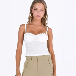 Elegant white camisole top with lace trim and padded cups paired with khaki cargo pants