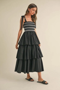 Detail of black tiered sundress with smocked bodice and adjustable ribbon bow straps