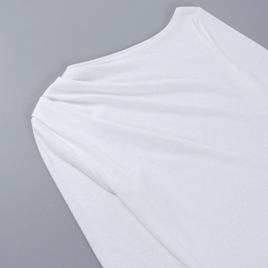 Detalle de camiseta blanca de manga larga con hombros fruncidos y textura de punto