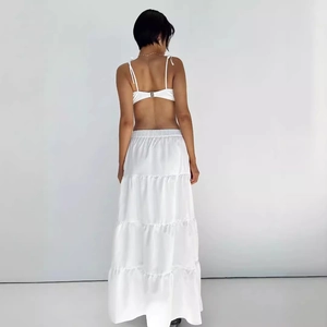 Women's chic white two-piece set featuring a backless crop top and tiered maxi skirt