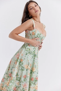 Detail of light green floral corset dress with thin straps and delicate flower patterns