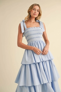 Detail of light blue tiered dress featuring smocked bodice and adjustable bow straps