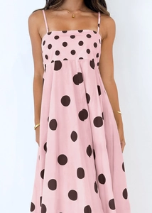 Detailed view of pink sundress with dark large polka dots and delicate spaghetti straps